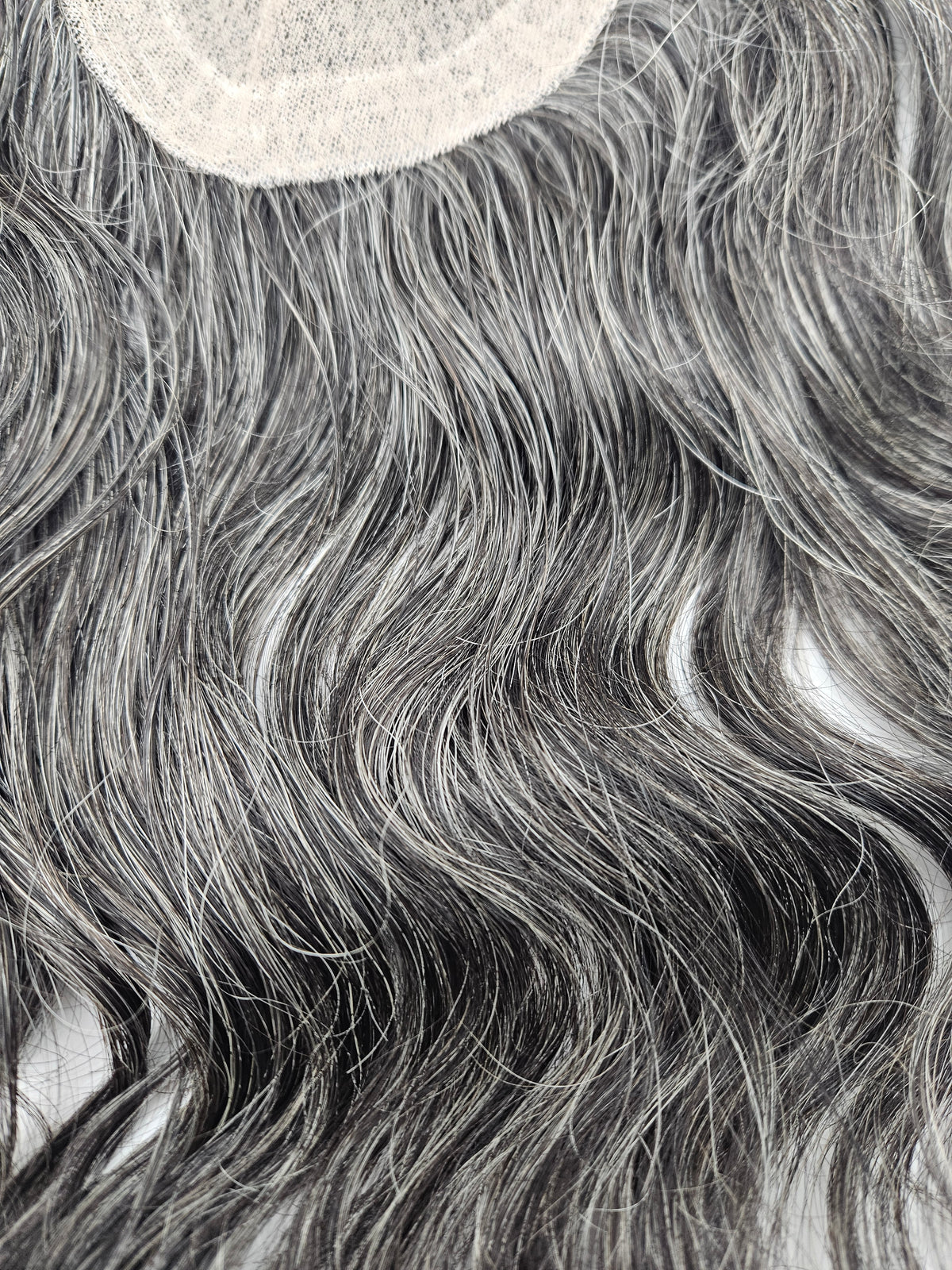 Close-up of natural black and silver gray blend on lace base hair topper
